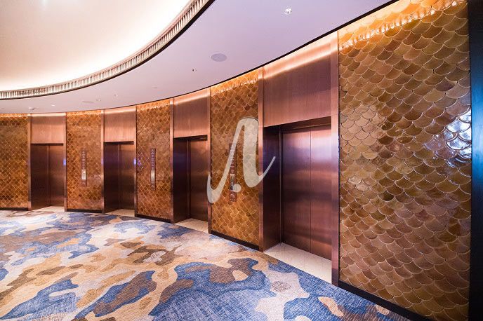 Không gian cửa thang máy ấn tượng với gạch mosaic vảy cá nâu hổ phách