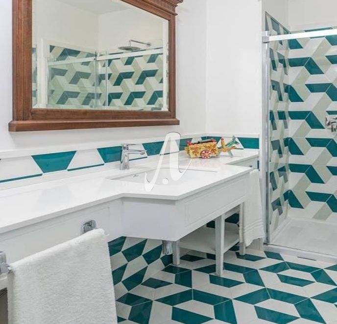 Phòng tắm với gạch tông màu trắng xen lẫn xanh lá giúp phòng tắm nhã nhặn và mát mắt