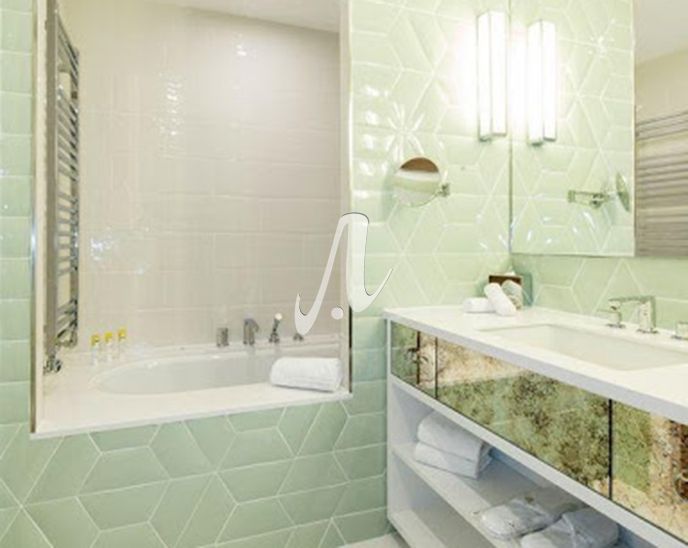 Màu xanh ngọc nhạt của những viên gạch mosaic thiết kế hình thang làm cho phòng tắm tươi sáng và sang trọng hơn