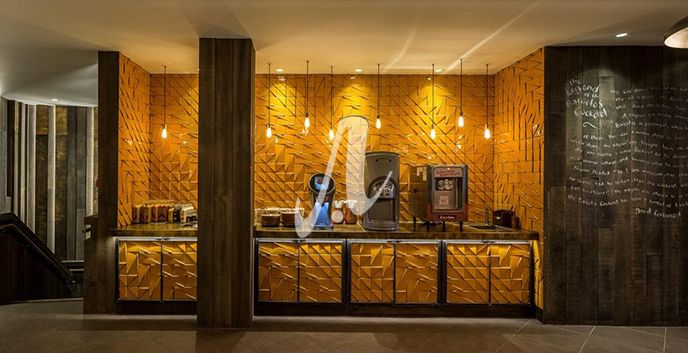 Quầy bar được trang trí bằng gạch 3D vàng cam tạo cảm giác rực rỡ và sống động hơn
