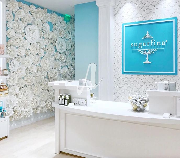 Trang trí bức tường với gạch vảy cá màu trắng phù hợp với tông màu nhẹ nhàng chủ đạo của cửa hàng