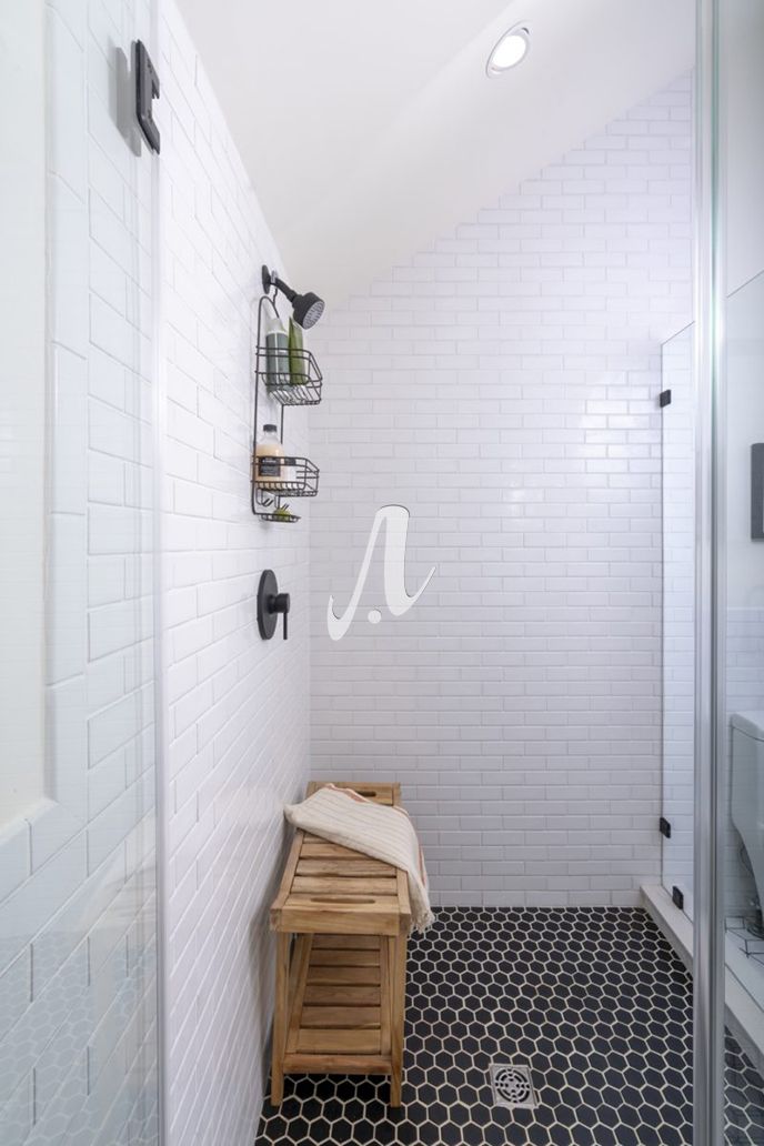 Nhà tắm sử dụng hai loại gạch mosaic với màu sắc trắng đen đơn giản, tạo nên sự đối lập ấn tượng cho không gian